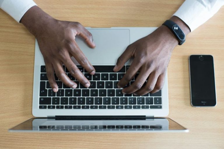 Professional Network - person's hand on MacBook near iPhone flat lay photography