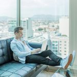 Social Media Freelancing - man sitting on sofa while using laptop