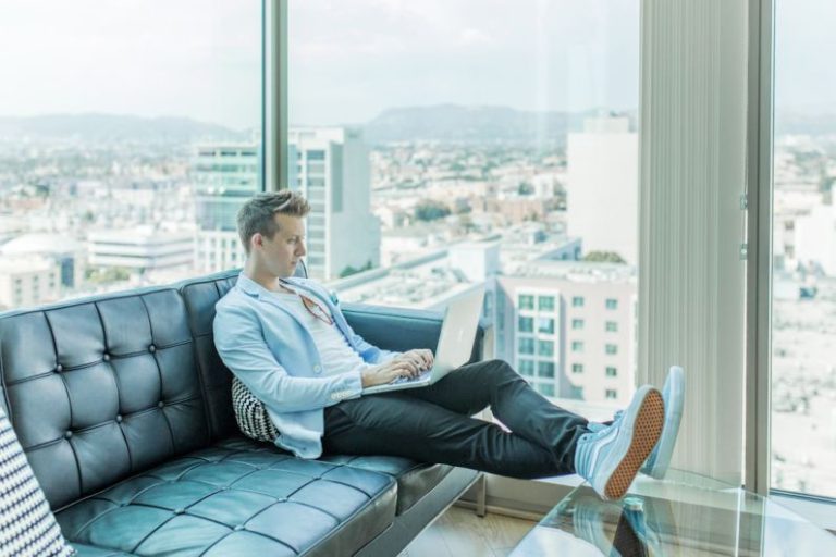 Social Media Freelancing - man sitting on sofa while using laptop