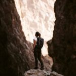 Difficult Clients - a person standing on a rock in a canyon