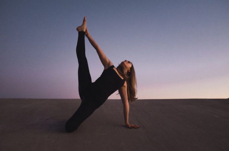 Flexibility Balance - woman holding her left leg high kneeling on floor