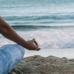 Mindfulness Practices - person in blue shorts sitting on beach shore during daytime