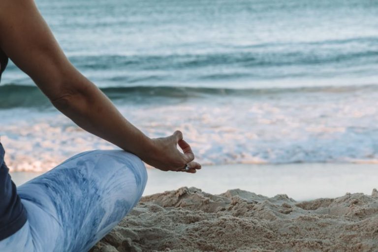 Mindfulness Practices - person in blue shorts sitting on beach shore during daytime