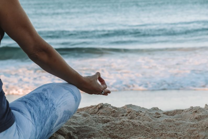 Mindfulness Practices - person in blue shorts sitting on beach shore during daytime