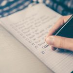 Time Management - person writing bucket list on book