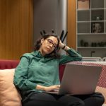 Flexible Schedule - a woman sitting on a couch using a laptop computer