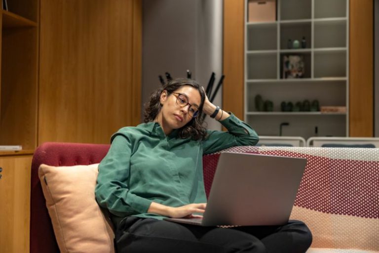Flexible Schedule - a woman sitting on a couch using a laptop computer