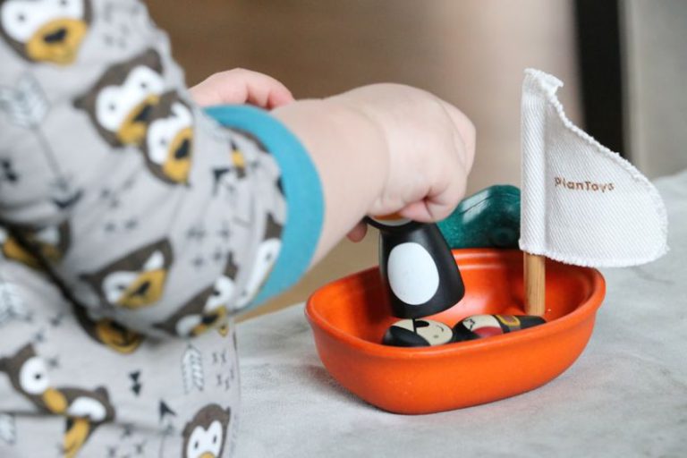 Ethical Implications - toddler playing plastic boat on mattress