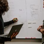 Collaborative Success - man wearing gray polo shirt beside dry-erase board