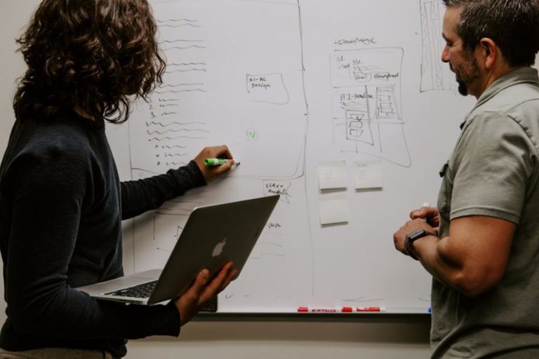 Collaborative Success - man wearing gray polo shirt beside dry-erase board