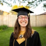 Empowering Communities - smiling woman in academic dress wearing academic hat