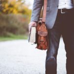 Career Path - man holding book on road during daytime