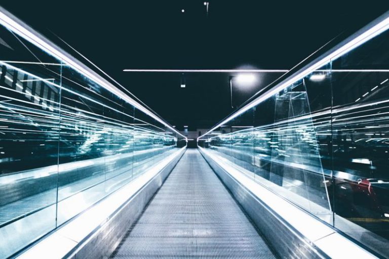 Upskilling Future - gray conveyor between glass frames at nighttime