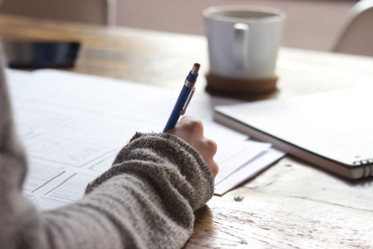 Mentorship Career - person writing on brown wooden table near white ceramic mug