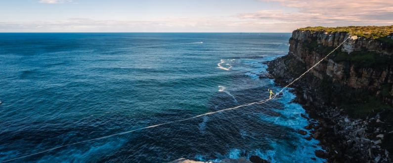 Resilience Success - a rope is attached to the edge of a cliff near the ocean