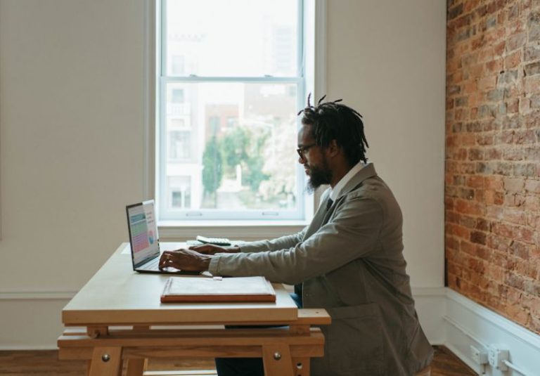 Remote Work - a person sitting at a desk with a laptop and papers