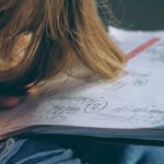 Alumni Networks - woman in blue denim jacket holding white paper