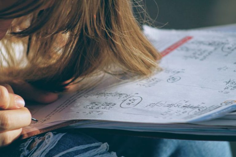 Alumni Networks - woman in blue denim jacket holding white paper