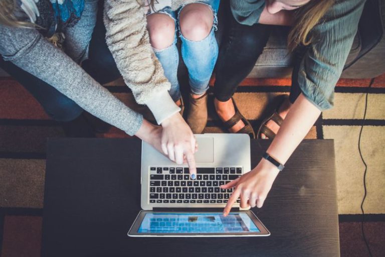 Online Communities - three person pointing the silver laptop computer
