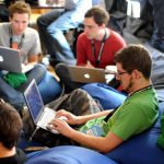 Peer Networking - man sitting on blue bean bag usinglaptop