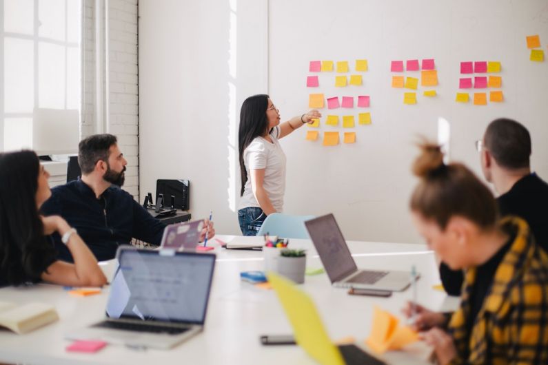 Global Networking - woman placing sticky notes on wall