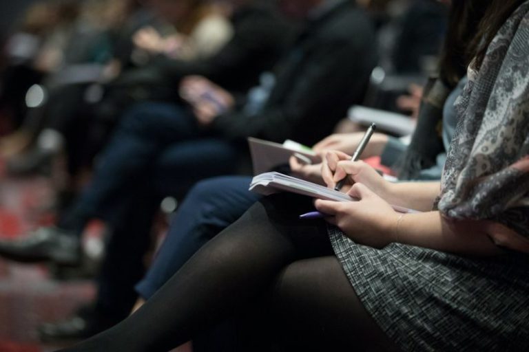 Networking Balance - selective focus photography of people sitting on chairs while writing on notebooks