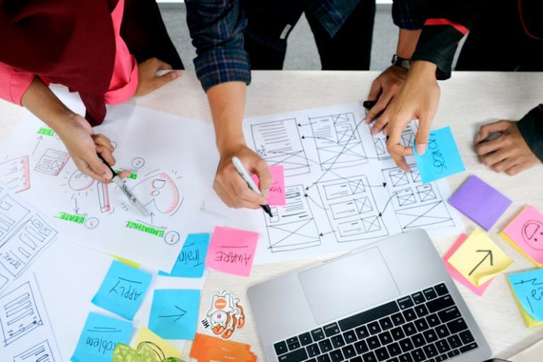 Design Thinking - person writing on white paper