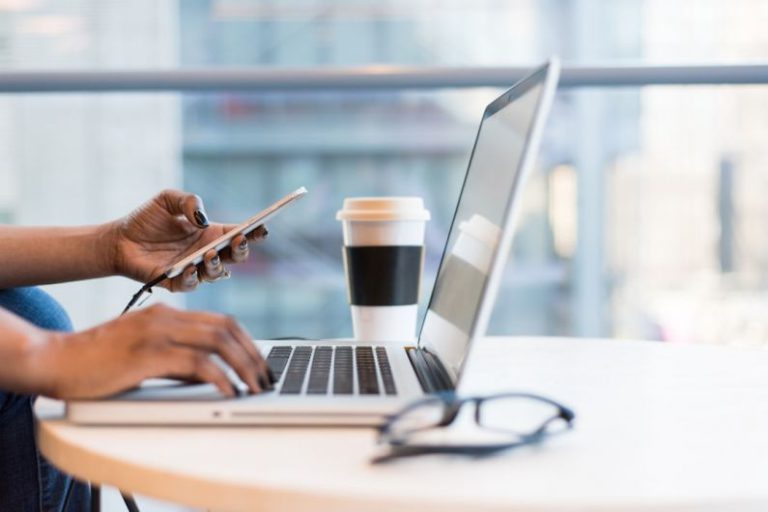 Technology Creative - person using smartphone and MacBook