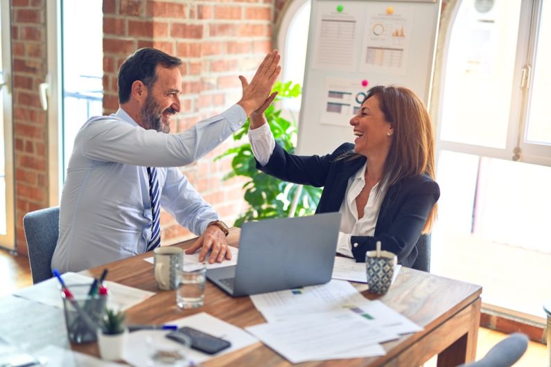 Teamwork Skills - man in white dress shirt sitting beside woman in black long sleeve shirt