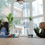 Funding Strategies - woman in black long sleeve shirt sitting beside woman in blue long sleeve shirt