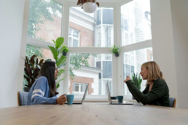 Funding Strategies - woman in black long sleeve shirt sitting beside woman in blue long sleeve shirt